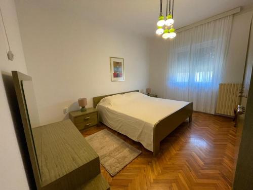 - une chambre avec un lit et du parquet dans l'établissement Apartman Goga, à Pula