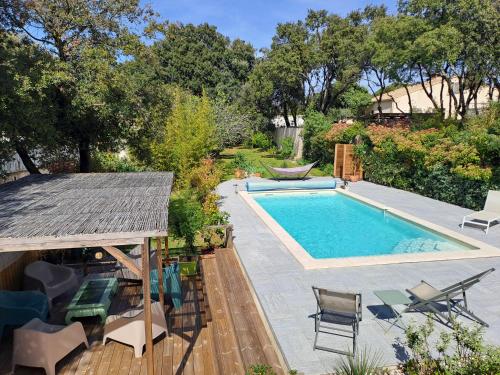 - une piscine dans une cour avec des chaises et une table dans l'établissement chambre d'hôte chez Suzel, à Sussargues