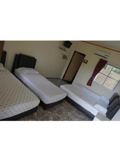 a room with two twin beds and a window at ACF Guest House in Sungai Lembing