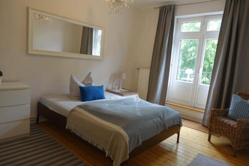 1 dormitorio con cama con espejo y ventana en Gr Wohnung mit 3 sep Schlafzimmern en Bremen