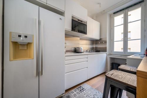 une cuisine blanche avec des armoires blanches et une fenêtre dans l'établissement B016 - Beautiful apt For 4 - Cannes center, à Cannes