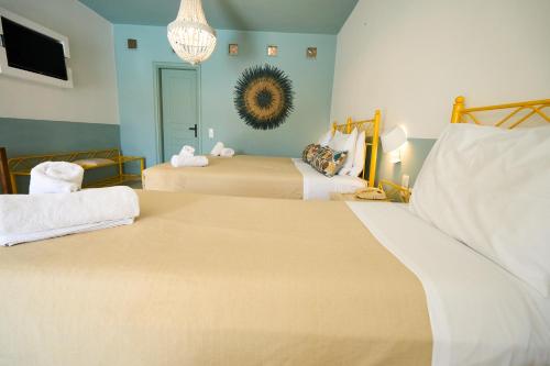a bedroom with two beds and a chandelier at Bellissimo Resort in Agios Ioannis Mykonos