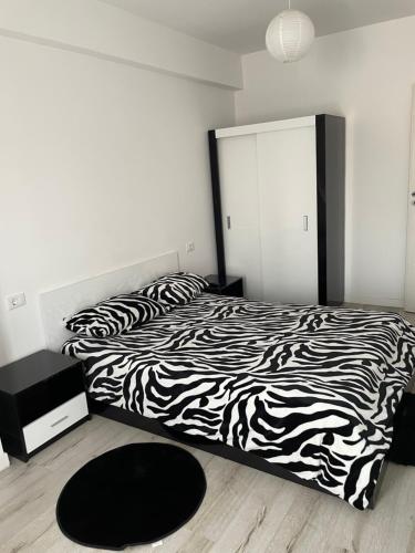 een slaapkamer met een zwart-wit bed en een spiegel bij MY LITTLE STUDIO in Craiova