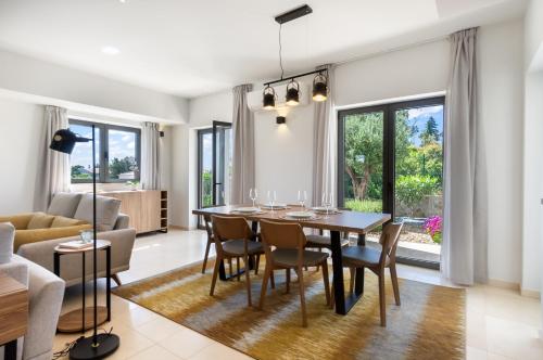 a dining room and living room with a table and chairs at Carvoeiro Gardens in Carvoeiro