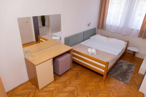 a small room with a bed and a desk at Motel New Sanatron in Bosanski Novi