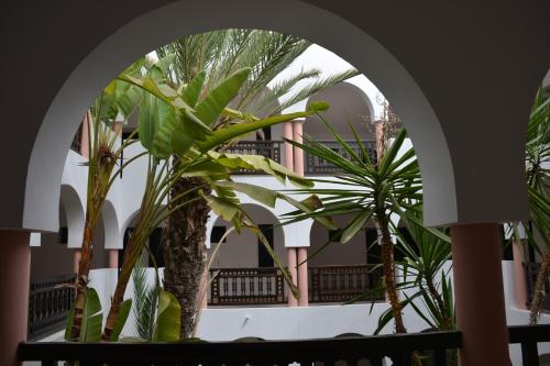 an archway with two palm trees in front of a building at Valeria Jardins d'Agadir - All In in Agadir