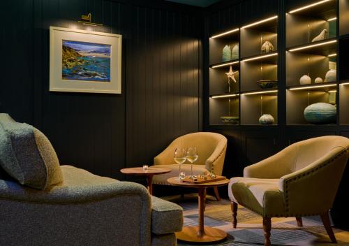 a room with two chairs and a table and wine glasses at Inchydoney Island Lodge & Spa in Clonakilty