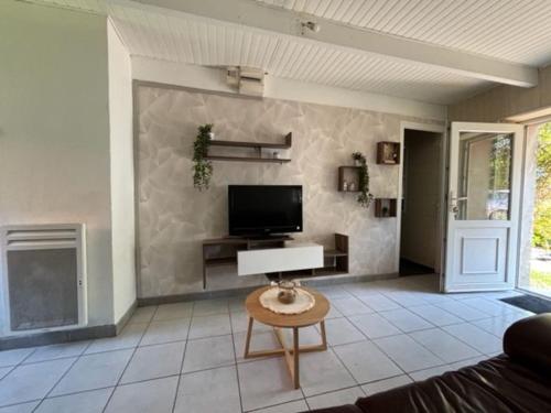 un salon avec une télévision à écran plat sur un mur dans l'établissement Petite maison à la campagne, à Mespaul