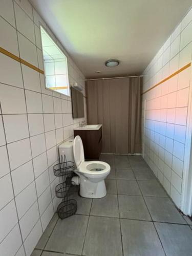 une salle de bain avec toilettes dans une pièce carrelée dans l'établissement Petite maison à la campagne, à Mespaul