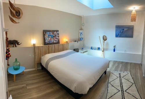 une chambre avec un grand lit blanc et une table dans l'établissement Maison de ville, Piscine, terrasse et jardin privé, à Bayonne