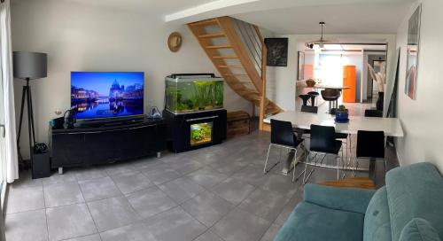 a living room with a tv and a fish tank at Maison de ville, Piscine, Jacuzzi et jardin privé in Bayonne