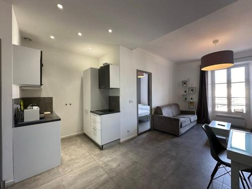 une cuisine et un salon avec un canapé et une table dans l'établissement B081 - Bel appartement Cannes - Tassigny, à Cannes