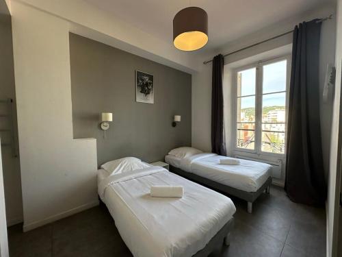 deux lits dans une chambre avec une fenêtre dans l'établissement B081 - Bel appartement Cannes - Tassigny, à Cannes