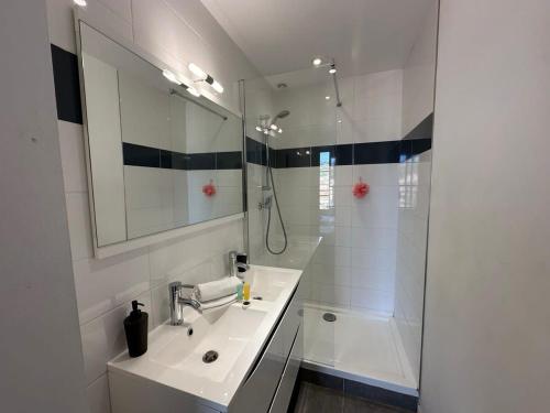 une salle de bain blanche avec un lavabo et une douche dans l'établissement B081 - Bel appartement Cannes - Tassigny, à Cannes