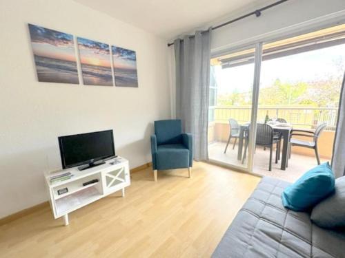 a living room with a couch and a television and a table at Playa, piscina, terraza, parking in Santa Pola