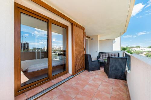 a balcony with two chairs and a bed on a balcony at Apartamento Parque Recoleta in Torrevieja