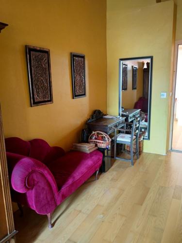 a living room with a purple couch and a mirror at Spillenberg House Main Property 2024 in Levoča