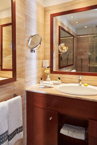 a bathroom with a sink and a large mirror at Villa Principe Leopoldo in Lugano
