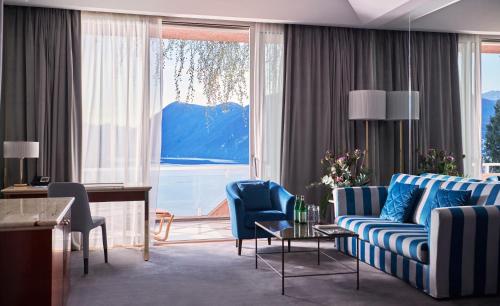 a living room with a couch and chairs and a large window at Villa Principe Leopoldo in Lugano