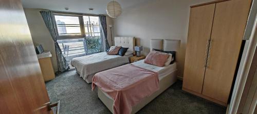 a bedroom with two beds and a window at Paramount city view in Swindon