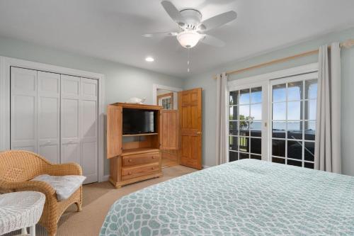 Un dormitorio con una cama y un televisor de pantalla plana. en MS22 Sandpiper's Retreat, en Nags Head