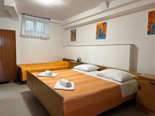 Dos camas en una habitación con toallas. en Apartment Bilić, en Pula