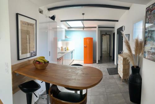 a kitchen with a wooden table with a bowl of fruit on it at Maison de ville, Piscine, Jacuzzi et jardin privé in Bayonne