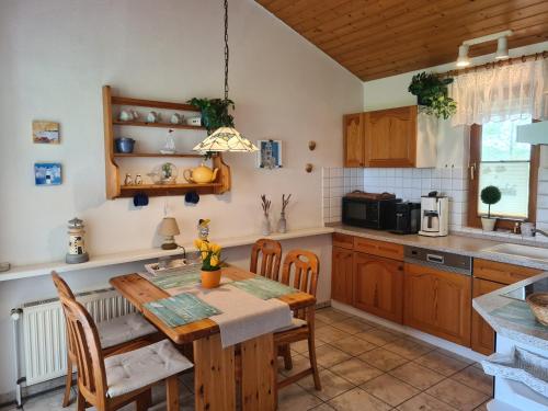 a kitchen with a wooden table and a dining room at Haus Austernfischer in Schweiburg