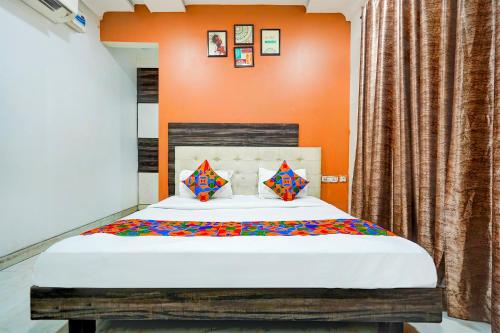 a bed in a room with an orange wall at FabHotel Season Grand in New Delhi