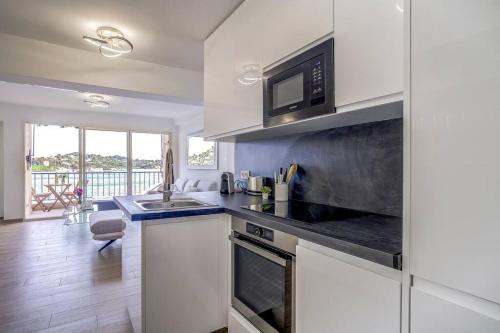 une cuisine avec un évier et un micro-ondes dans l'établissement Stunning Waterfront Apartment, à Villefranche-sur-Mer