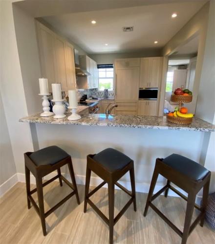 a kitchen with a large counter with two stools at Endless Summer 42 in Key Largo