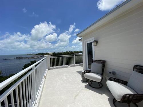 a balcony with two chairs and a view of the water at Endless Summer 42 in Key Largo