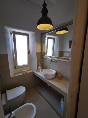 a bathroom with a toilet and a sink and a mirror at Masseria a libeccio in Maruggio