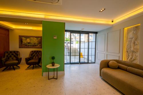 a living room with a couch and a green wall at DeMANOR HOTEL ADULT ONLY in Alanya