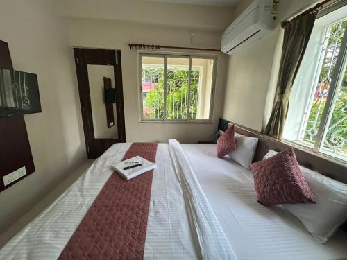 a bedroom with a bed with a book on it at Chopson's Parc in Thākurdwari