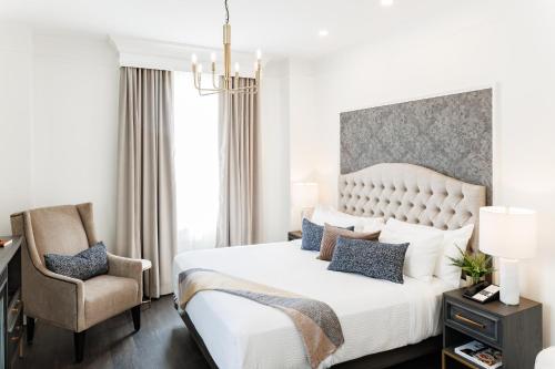 a bedroom with a large white bed and a chair at Rodd Charlottetown in Charlottetown