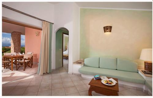 a living room with a couch and a table at Hotel Relax Torreruja Thalasso & Spa in Isola Rossa