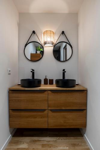 une salle de bain avec deux lavabos et deux miroirs dans l'établissement La maison des canailles, à Cassis
