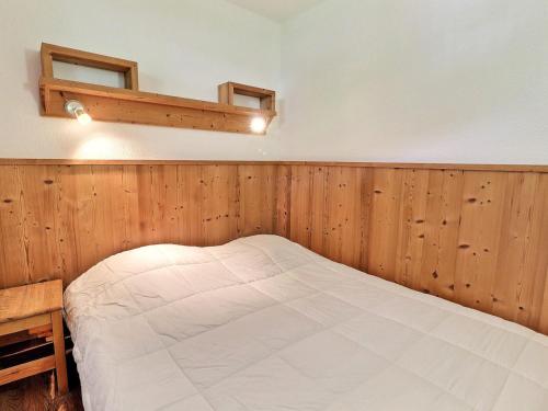 łóżko w pokoju z drewnianymi panelami w obiekcie Appartement 2 Pièces à La Tania, 4 Pers, Skis aux Pieds, Balcon Est - FR-1-182A-6 w Courchevel