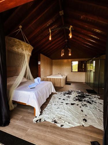 a bedroom with a bed and a large rug at LaDomita in Camanducaia