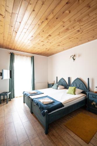 a bedroom with a large bed with a wooden ceiling at Dinvis Apartments in Poiana Brasov