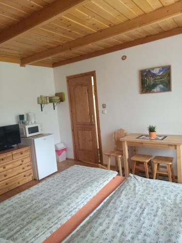 sypialnia z łóżkiem oraz kuchnia ze stołem w obiekcie Pokoje u Micka Poronin 5 km od Zakopanego w Poroninie