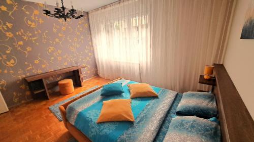 - une chambre avec un lit doté de draps bleus et d'oreillers jaunes dans l'établissement Central Park Apartment, à Čačak