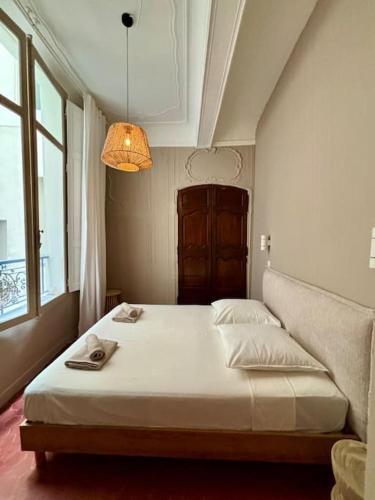 - une chambre avec un lit blanc et une lampe dans l'établissement Splendide T2 au coeur d'Aix et du Cours Mirabeau, à Aix-en-Provence