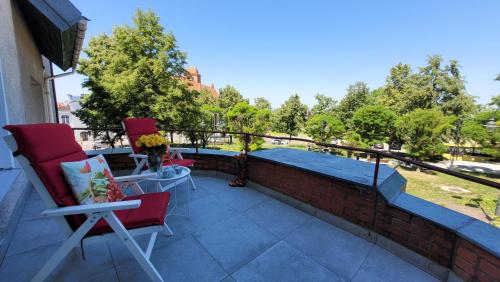 a patio with two chairs and a table on a brick wall at Apartamenty Parkowe nr 5 in Kwidzyn