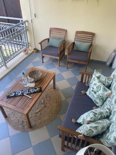 a living room with a couch and a table and chairs at La Valentine Résidence La Plantation Sainte Marthe in Saint-François