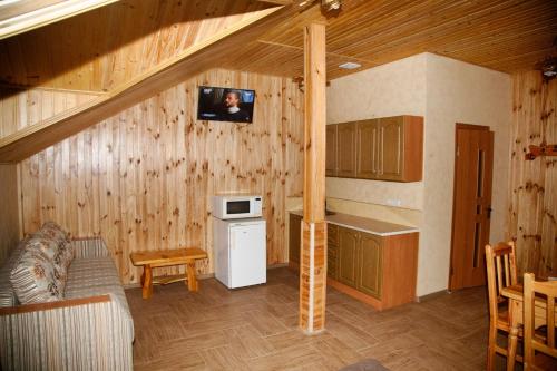 a kitchen with wooden walls and a person in a picture on the wall at Mini-hotel Yandrusi in Kamianets-Podilskyi