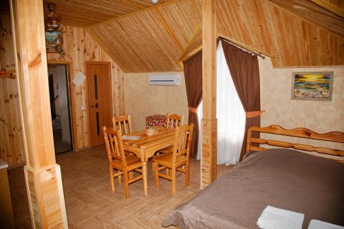 a bedroom with a bed and a table and chairs at Mini-hotel Yandrusi in Kamianets-Podilskyi