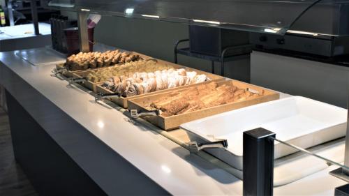 una cocina con varias sartenes de comida en una barra en Ohtels Mazagon, en Mazagón