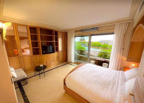 a bedroom with a bed and a large window at Les Amoureux de Paris in Paris